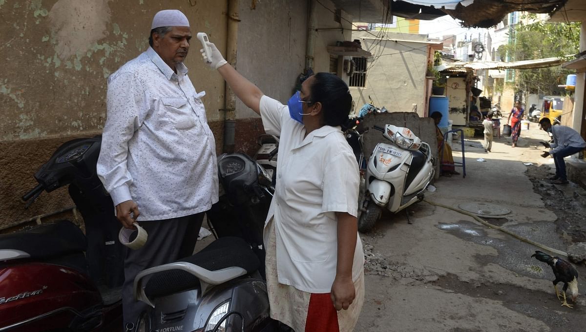 A health official conducts a temperature check  during a door-to-door Covid-19 survey in Hyderabad..