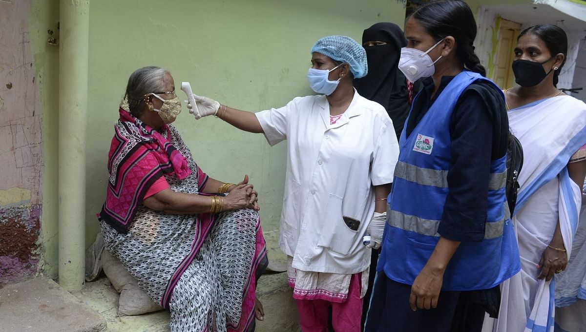 A health officer conducts a temperature check of an elderly woman in Hyderabad.