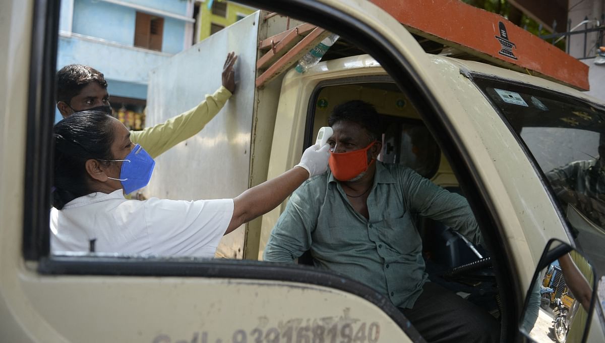 A health worker checks the body temperature of a resident during a door-to-door survey to monitor for Covid-19 coronavirus symptoms in Hyderabad.