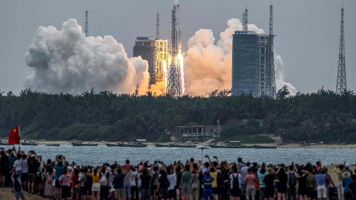 People watch a Long March 5B rocket, carrying China's Tianhe space station core module, as it lifts off from the Wenchang Space Launch Center in southern China's Hainan province. Credit: AFP Photo