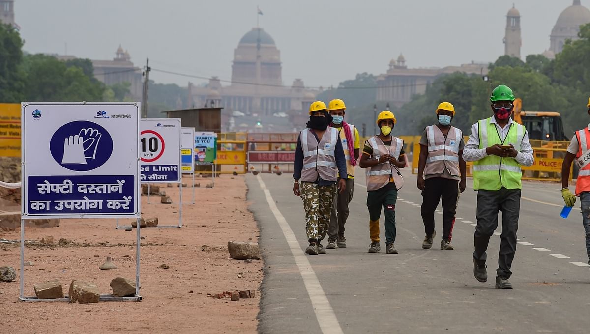 Labourers take a break from construction work as part of the Central Vista Redevelopment Project, at Rajpath in New Delhi.