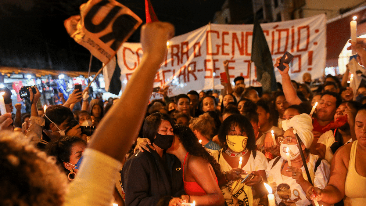 Relatives of victms hold candles as people protest against police violence outside Jacarezinho slum, after a police operation which resulted in 25 deaths, in Rio de Janeiro, Brazil. Credit: Reuters Photo