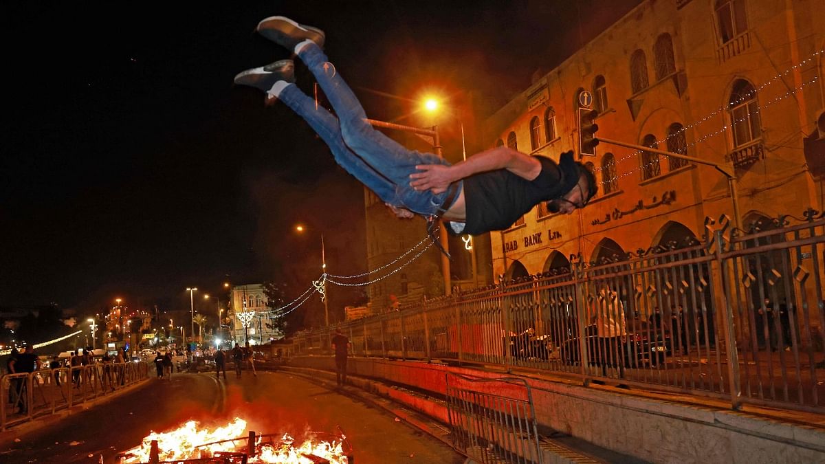 A Palestinian protester is seen in midair during a parkour stunt near an Israeli security barrier outside the Damascus Gate in Jerusalem's Old City. Credit: AFP Photo