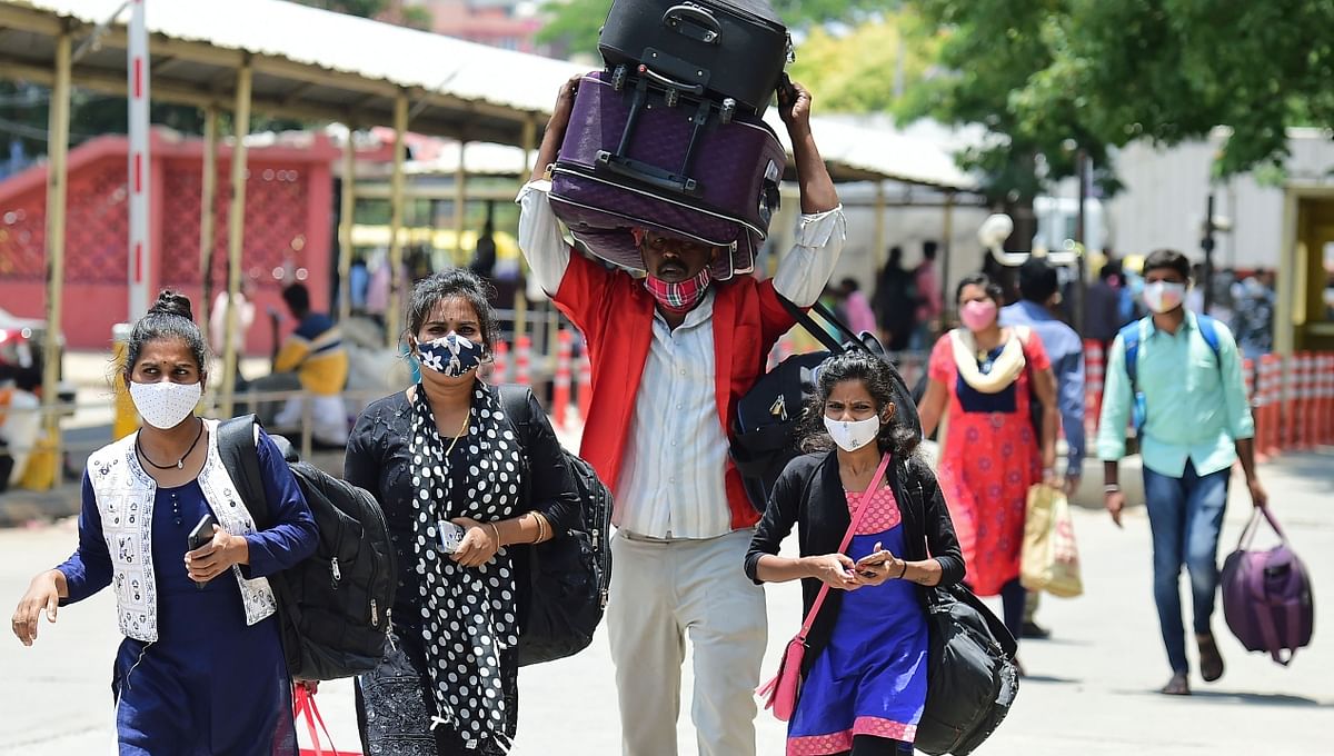 Migrant workers and others arrive to catch trains in Bengaluru.