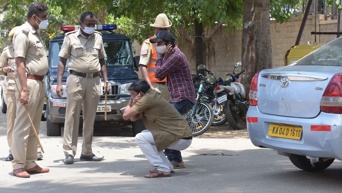 Locals are made to do sit-ups on the road by policemen for violating prohibitory orders.