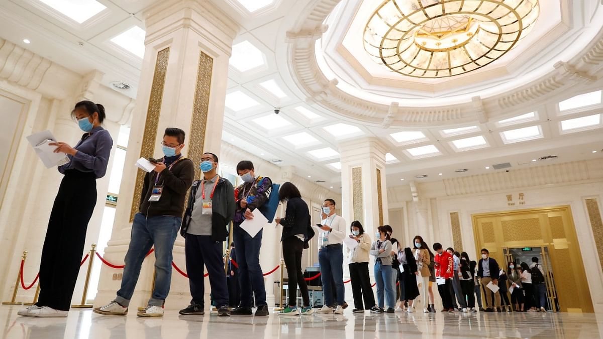 Journalists line up to pick up a copy of China's National Bureau of Statistics population census report before a news conference in Beijing. Credit: Reuters Photo