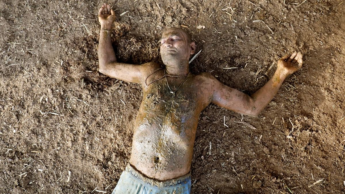 Ashok Oza rests after applying cow dung on his body during