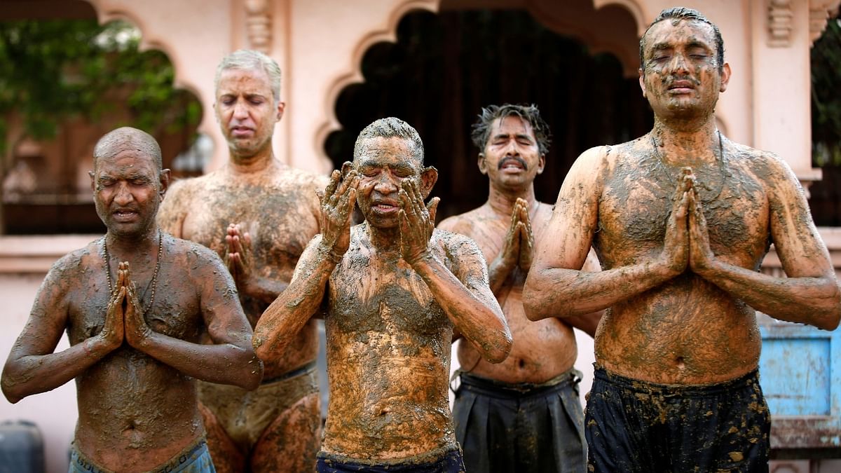 People pray after applying cow dung on their bodies during
