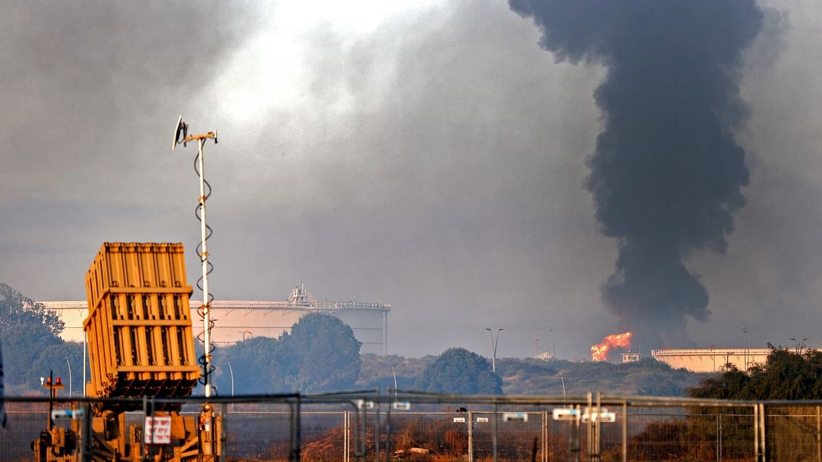 An Iron Dome aerial defence system battery is seen in the foreground (L) as fire rages early on May 12, 2021 at Ashkelon's refinery. Credit: AFP