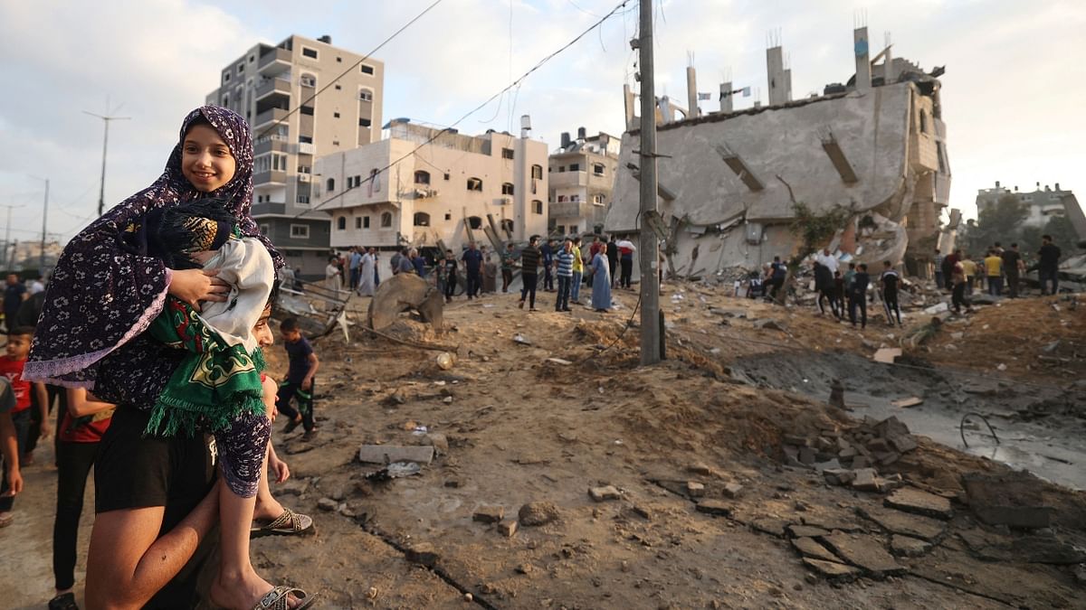 People gather outdoors as they see the destruction caused by Israel bombardment in the northern Gaza Strip town of Beit Lahia. Credit: AFP Photo