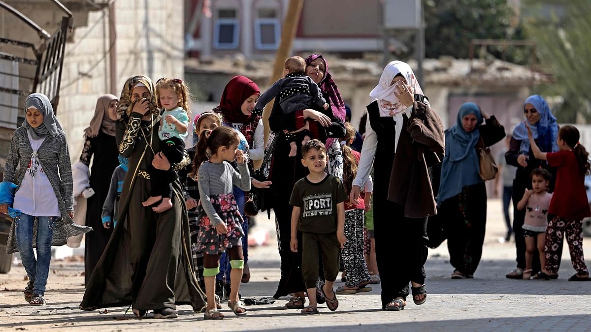 Palestinians women and their children flee to a safer location after heavy air and artillery strikes by Israel.