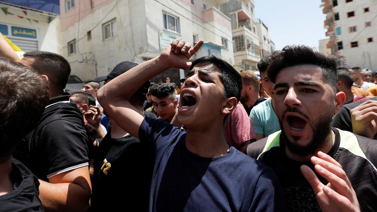 People react as others carry the body of Hussien al-Titi, who was killed during stone-throwing clashes with Israeli forces, during his funeral at Fawwar refugee camp near Hebron in Jerusalem.