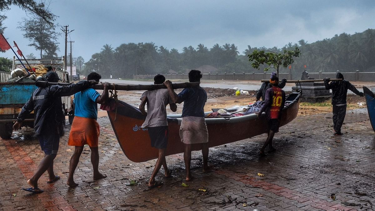 Fishermen carry their boats away from the shore due to formation of Cyclone Tauktae in the Arabian Sea, in Mangaluru.