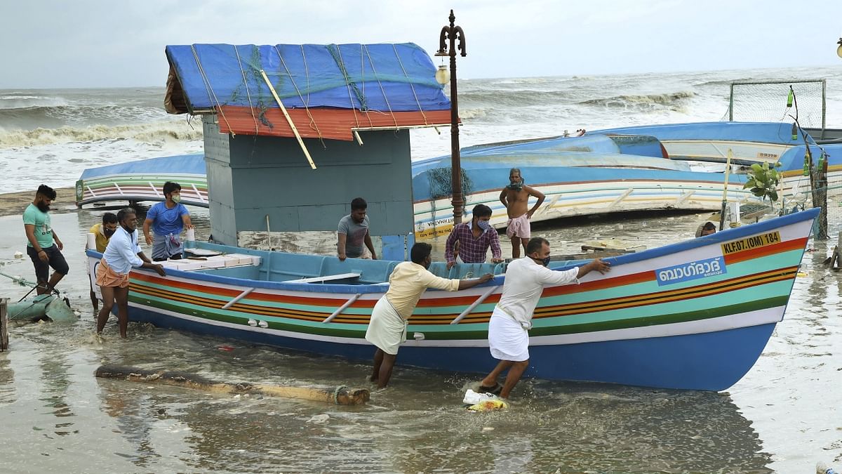 People remove fishing boats from the seashore ahead of cyclone Tauktae, at Baypore in Kozhikode, Kerala.