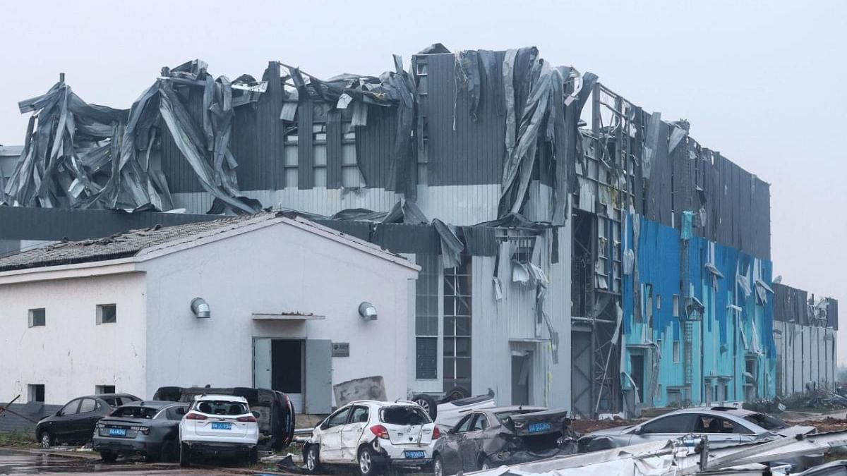 A damaged building and vehicles are pictured after a tornado hit an economic zone in Wuhan in China's central Hubei province. Credit: AFP Photo