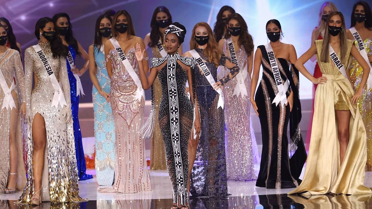 Miss Universe 2019 Zozibini Tunzi waves as she walks on the stage.