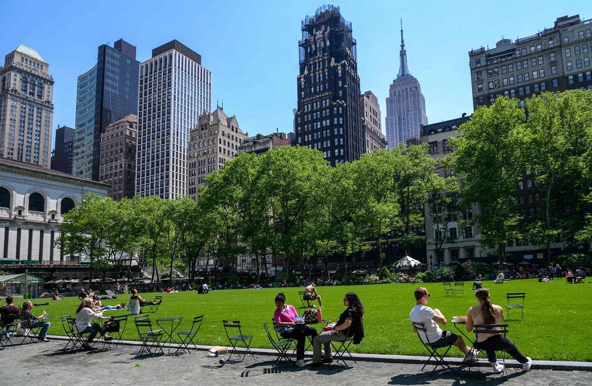 People sit in the sun at Bryant Park in midtown Manhattan in New York City. US CDC announced that fully vaccinated people in the country could shed face masks, a key step in returning to normalcy after Covid-19 lockdowns. Credit: AFP Photol