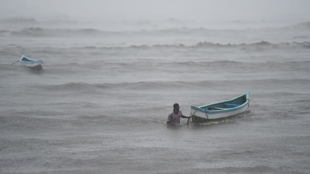 A fisherman tries to pull his boat ashore to a safe place during the formation of cyclone Tauktae, at Bandra. Credit: PTI