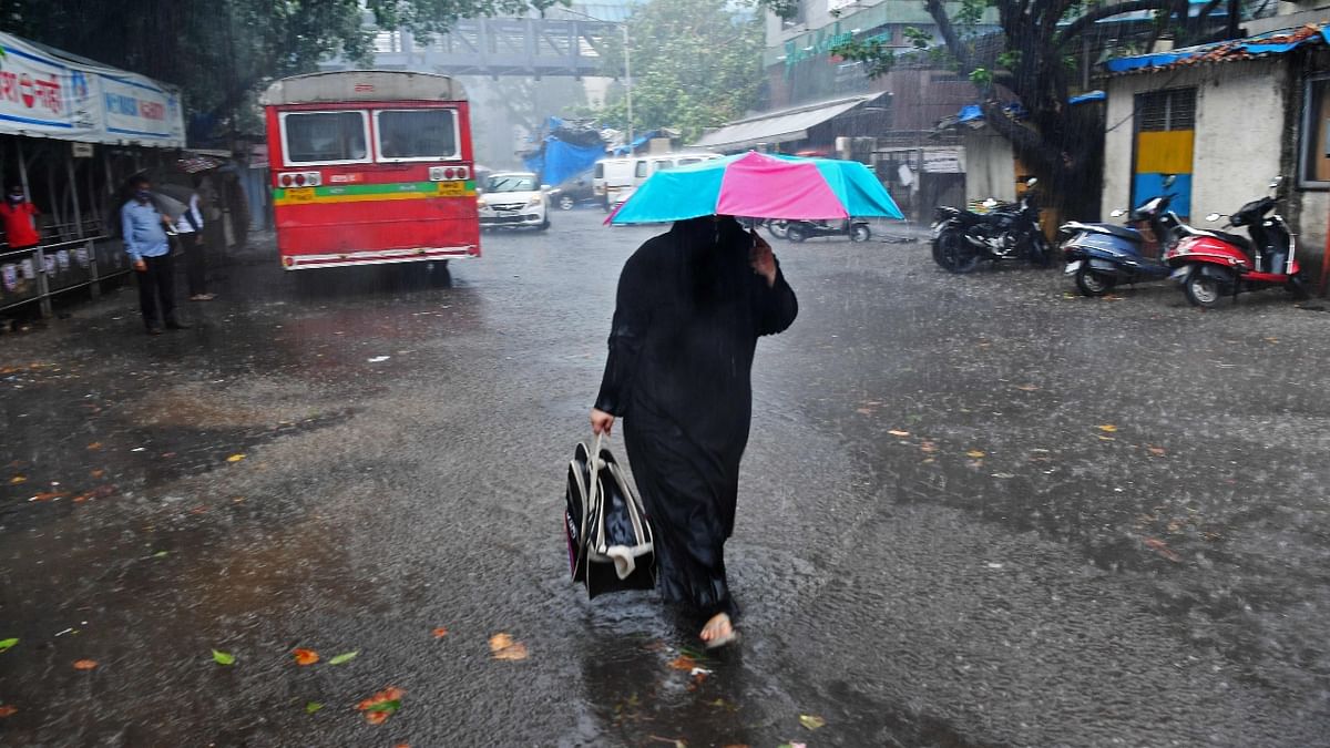 A woman walks through a road following heavy rains from cyclone Tauktae in Mumbai. Credit: PTI