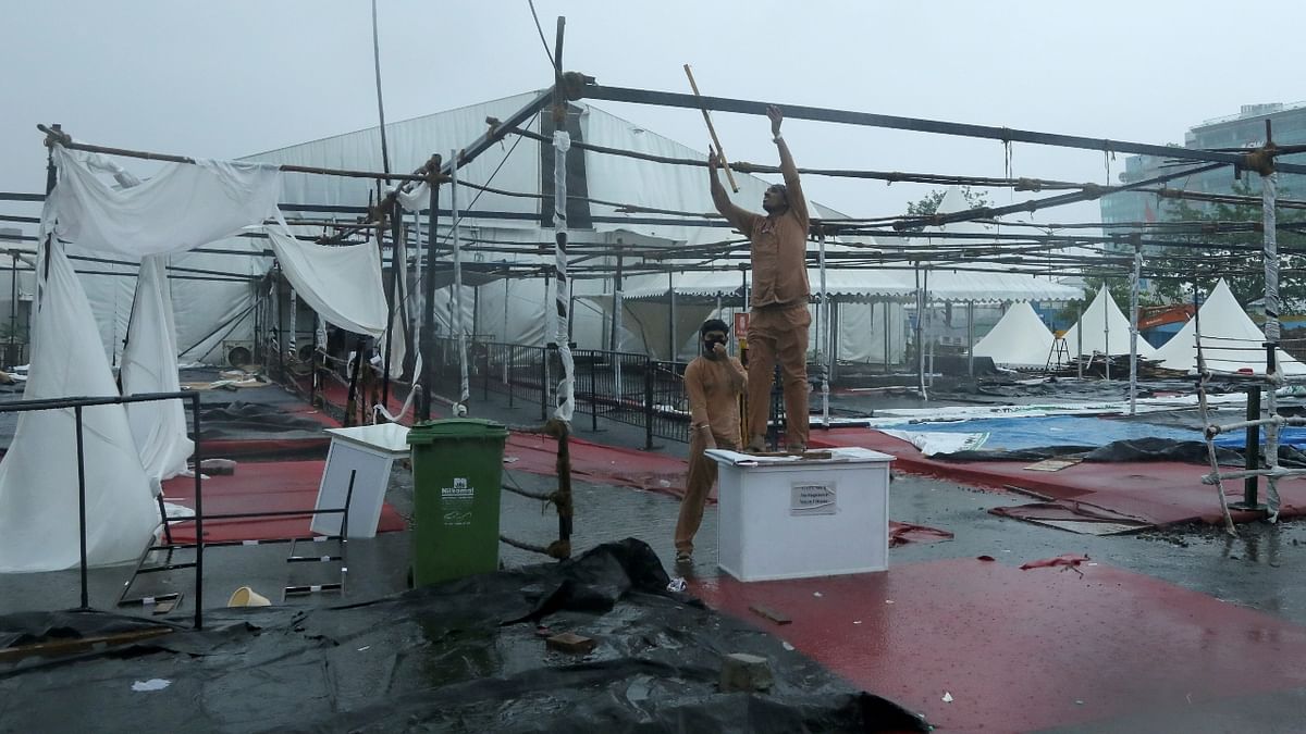 Workers are seen fixing the damaged tents at a coronavirus disease (COVID-19) vaccination centre. Credit: Reuters