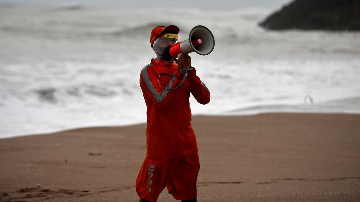 A member of the National Disaster Response Force (NDRF) uses a megaphone to appeal to fishermen to stay away from the shore ahead of Cyclone Tauktae in Veraval in the western state of Gujarat. Credit: Reuters