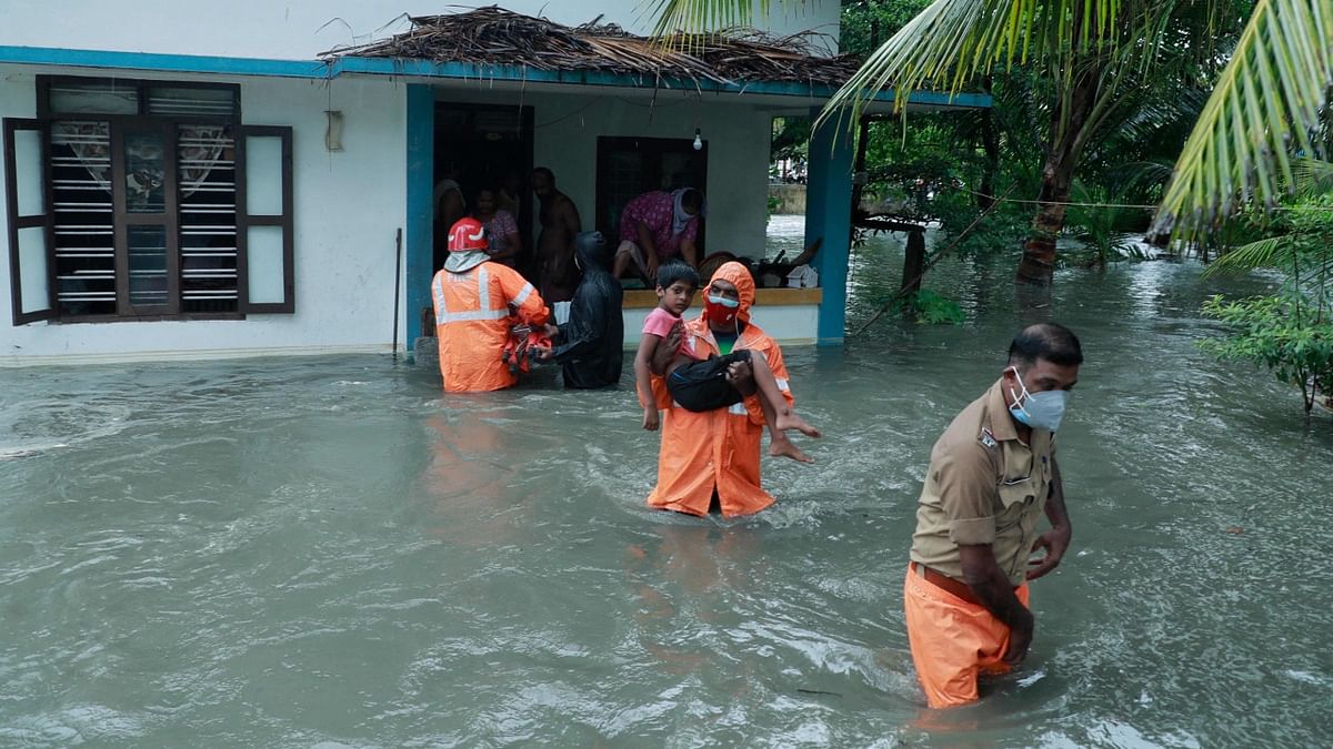 Police and rescue personnel evacuate local residents from a flooded house in a coastal area after heavy rains under the influence of cyclone Tauktae in Kochi. Credit: AFP
