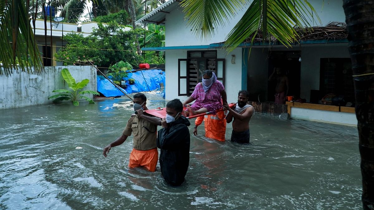 Police and rescue personnel evacuate local residents from a flooded house in a coastal area after heavy rains under the influence of cyclone Tauktae in Kochi. Credit: AFP