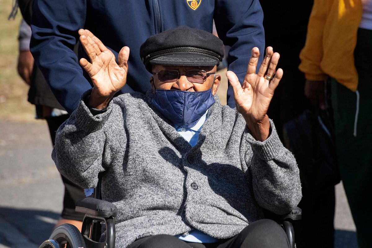 Desmond Tutu, Archbishop Emeritus and Nobel Peace Laureate, greets wellwishers as he is wheeled out of the Brooklyn Chest Hospital, after being vaccinated against Covid-19 in Cape Town. Credit: AFP Photo