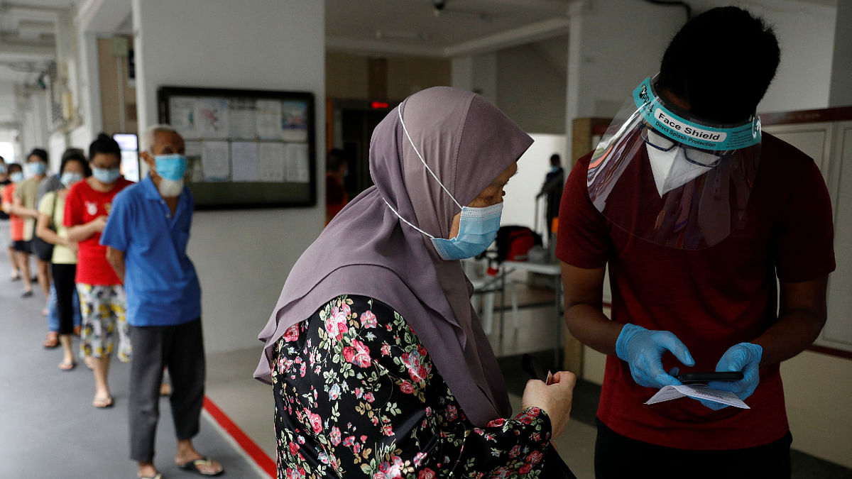 Residents of a public housing estate queue up for their mandatory Covid-19 swab tests after some residents were tested positive for the virus. Credit: Reuters Photo