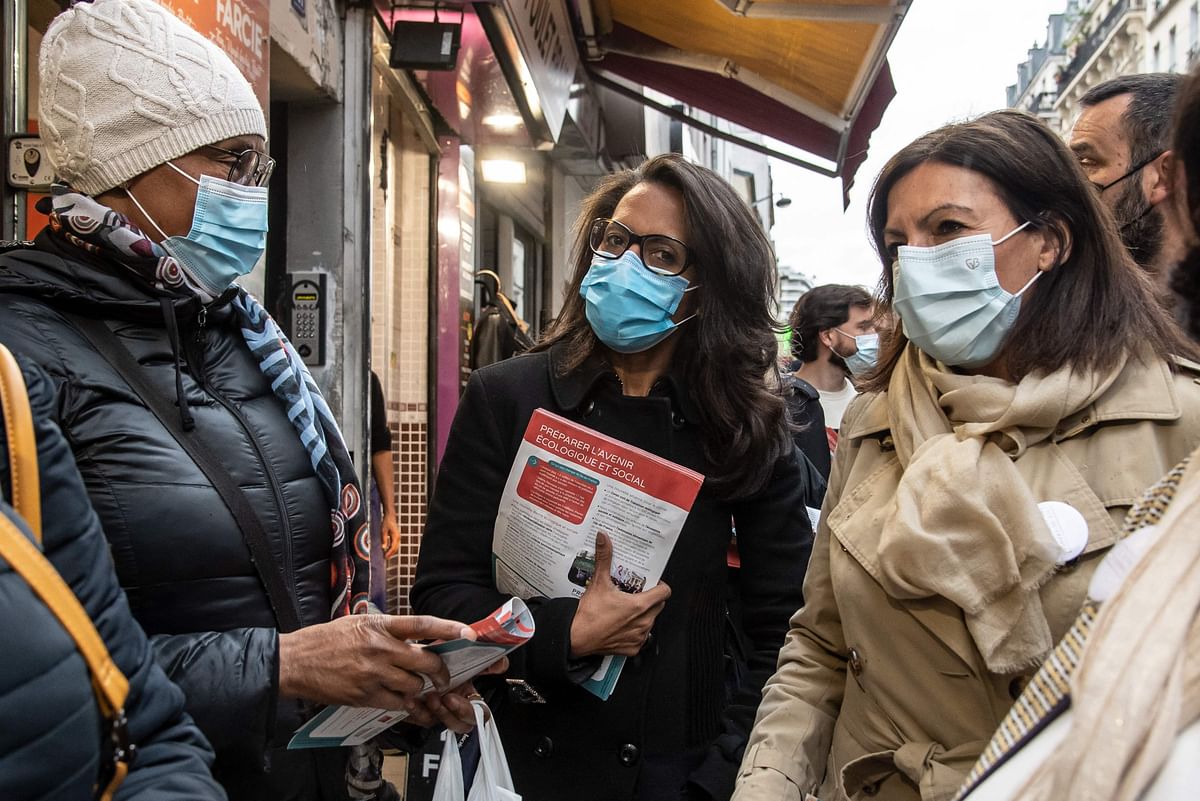 Paris' Socialist deputy mayor to urban farming and candidate for the June 2021 regional elections in Ile-de-France Audrey Pulvar (C) and Mayor of Paris Anne Hidalgo (R) pass on electoral flyers in the Belleville district of Paris. Credit: AFP Photo