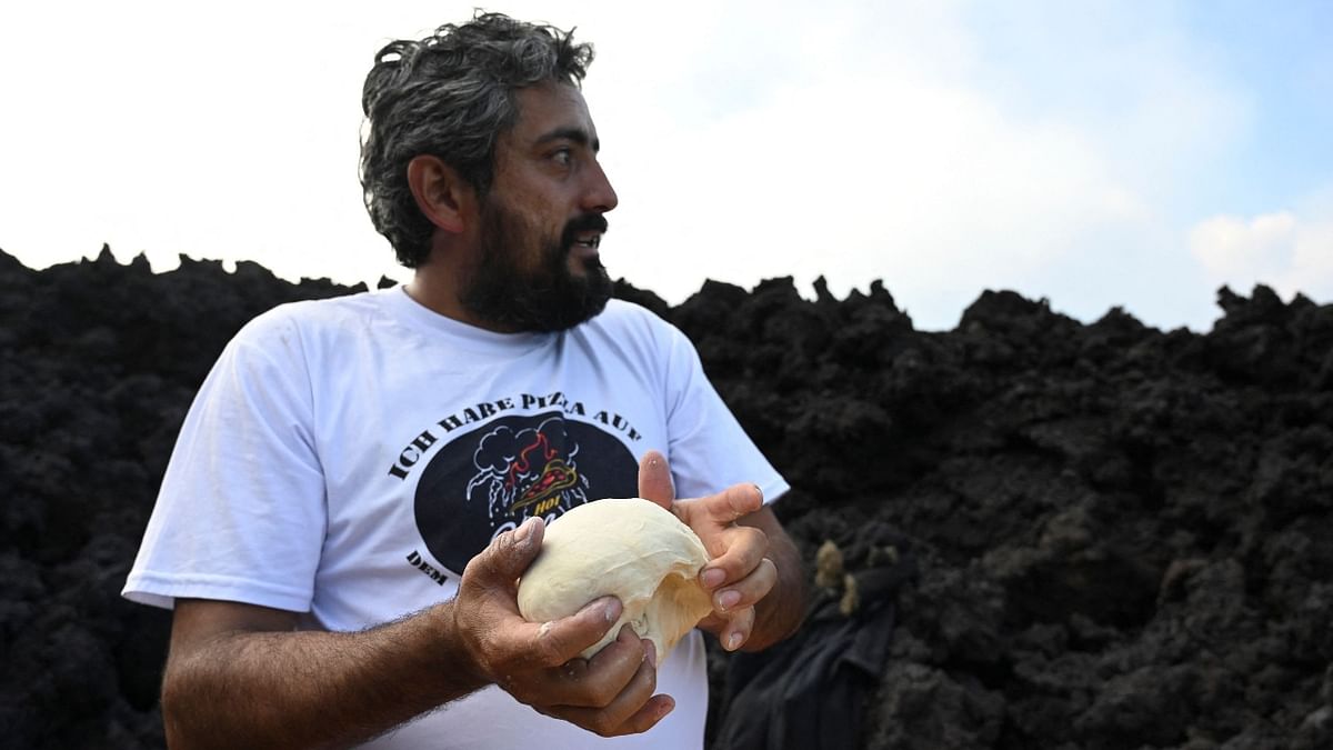 David Garcia prepares a pizza dough to cook on the lava rivers that come down from the Pacaya volcano in Guatemala.