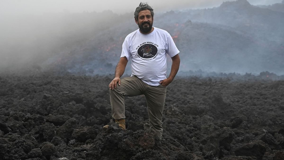 Wearing protective clothing from head to his military style boots, Garcia places the pizza on the lava. He first started baking pizzas on the mountain side in 2013 in small caverns he found amongst the rocks.