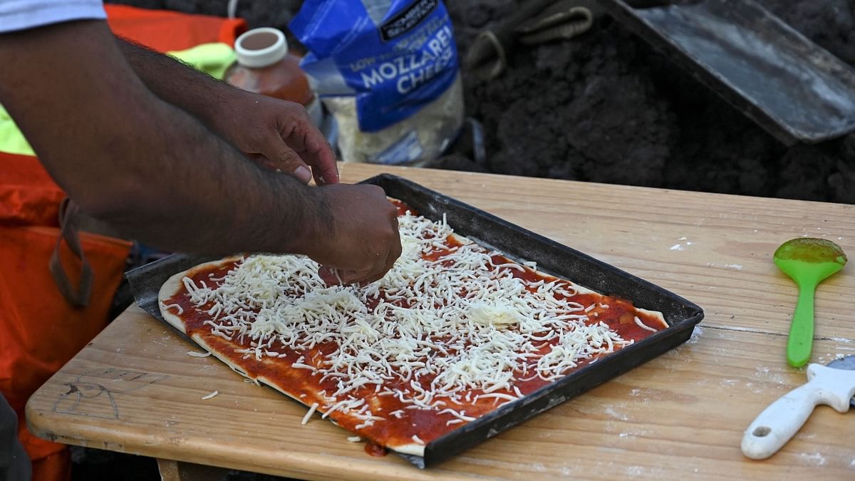 David Garcia is seen preparing a pizza.