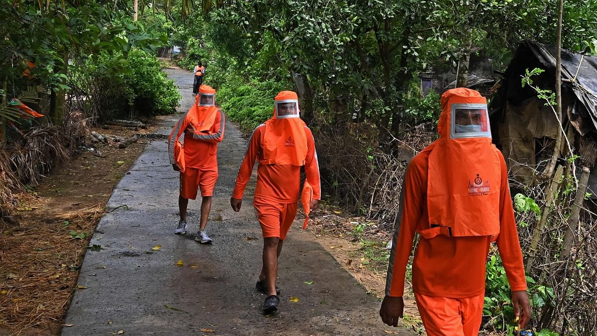 National Disaster Response Force (NDRF) personnel walk along a village road urging the villagers to evacuate and shift to a safer place before the landfall of cyclone “Yaas” in Digha, Kolkata. Credit: PTI