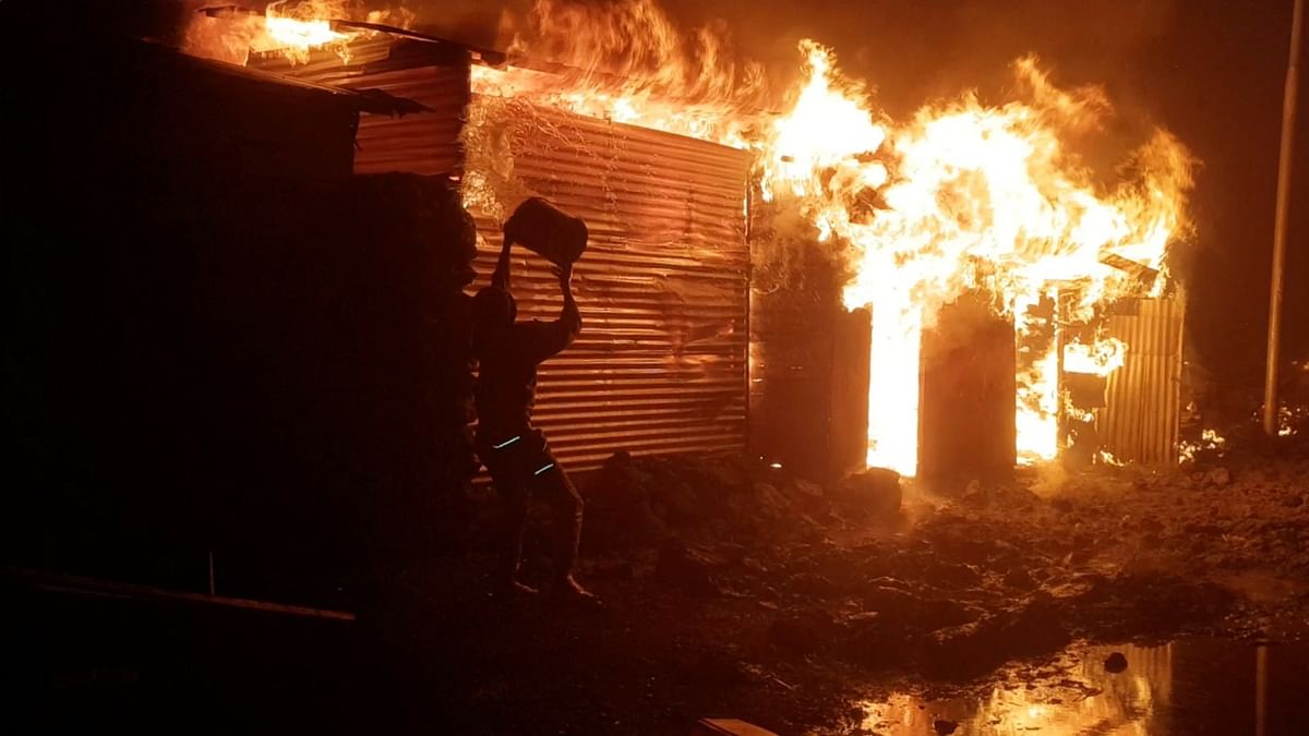 A person attempts to extinguish fire on a building after the volcanic eruption of Mount Nyiragongo, in Goma, Democratic Republic of Congo.