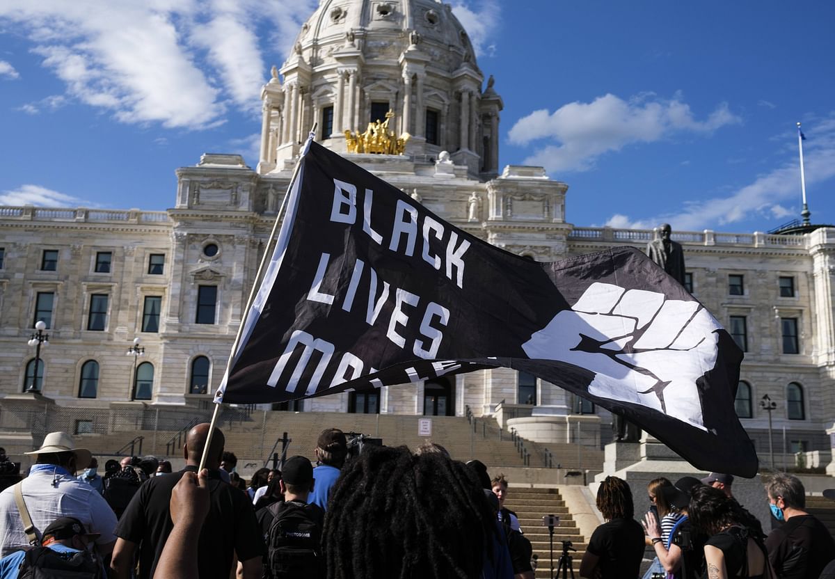 A demonstrator holds a Black Lives Matter flag outside the Minnesota State Capitol building on May 24, 2021 in St Paul, Minnesota. Credit: AFP Photo