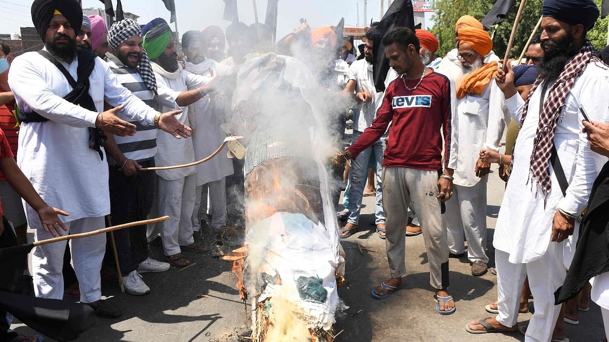 From raising black flags to burning effigies, farmers from other states showed their solidarity with the protesting farmers who are demanding the repeal of the controversial farm laws. Credit: AFP Photo