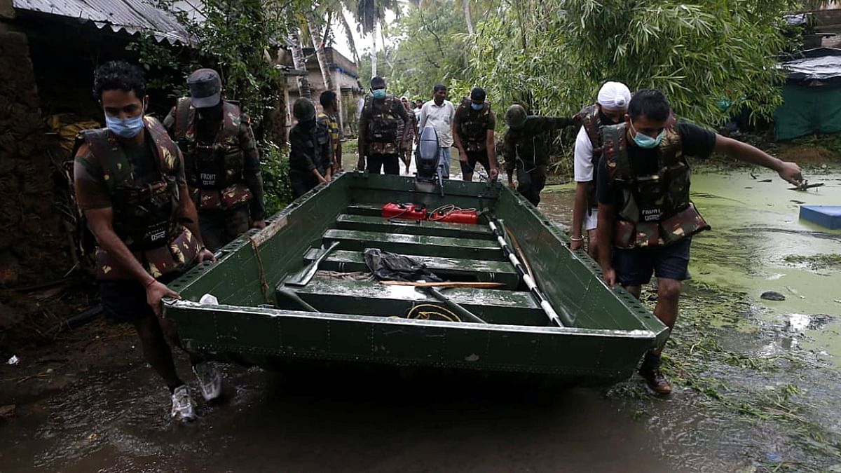 Army carry a boat to evacuate people from a flooded area as Cyclone Yaas makes landfall at Ramnagar in Purba. Credit: Reuters Photo