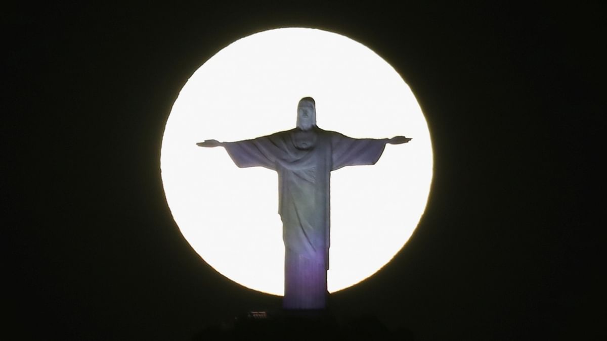 The super moon shines behind the Christ the Redeemer statue in Rio de Janeiro, Brazil. Credit: Reuters Photo