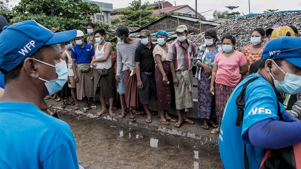 Millions of people in Myanmar are seen standing in line to get food aid efforts to support residents living in poor communities in Yangon.