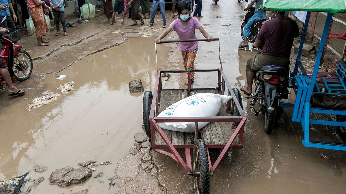 A girl pushes a wheelbarrow with a bag of rice distributed by the World Food Programme (WFP) as part of food aid efforts.