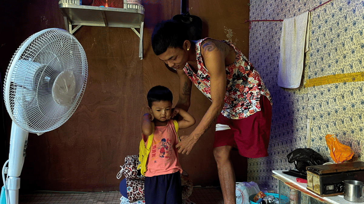 Ko Phyo, 24, a protester who lost one leg during an anti-coup protest, prepares to leave with and his two-year-old son Paing Phyo Oo, at his home on the outskirts of Yangon, Myanmar. Credit: Reuters Photo