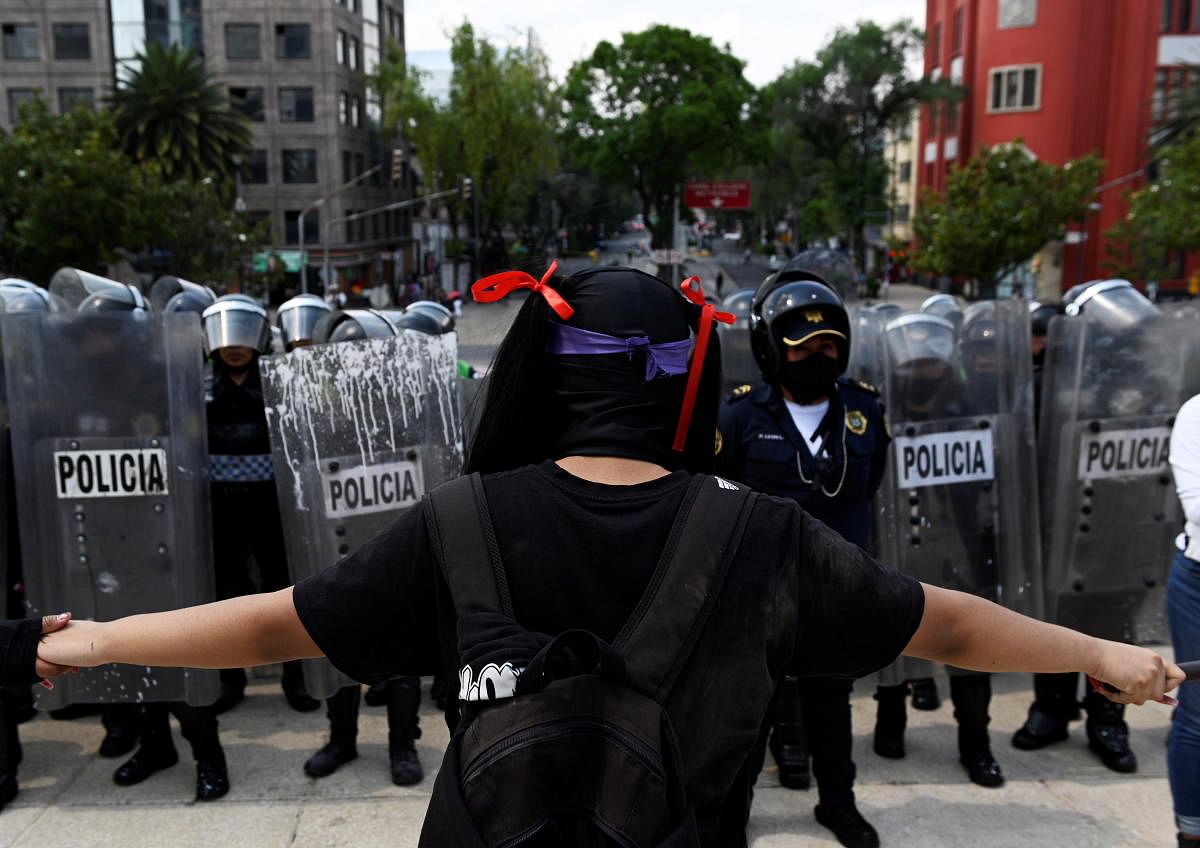 Demonstrators hold each other hands while facing the police during a protest of feminist collectives against the police and the excess of public force used to disperse peaceful protests, in downtown Mexico City, Mexico. Credit: Reuters Photo