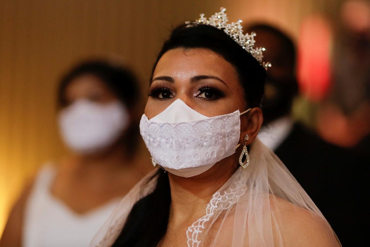 A bride listens to the judge during a mass wedding, amid the spread of the coronavirus disease, at Brasilia's national museum in Brasilia. Credit: Reuters Photo