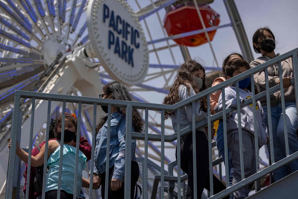 People stand in line for a ride at Pacific Park amusement park on the Santa Monica Pier as crowds gather on Memorial Day as shutdowns are relaxed more than a year after Covid-19 pandemic shutdowns began, in Santa Monica, California. Credit: AFP Photo