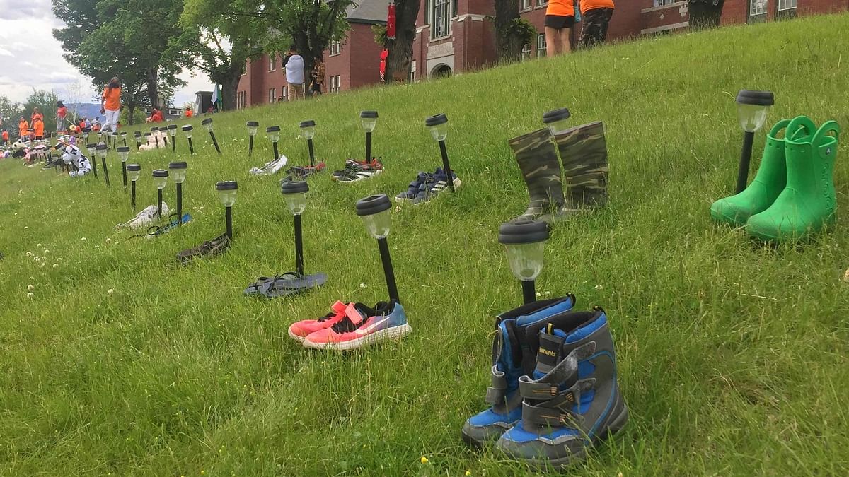Tributes of shoes are left at the Kamloops Indian Residential School in memory of the 215 children's bodies found on the residential school site. Credit: AFP Photo