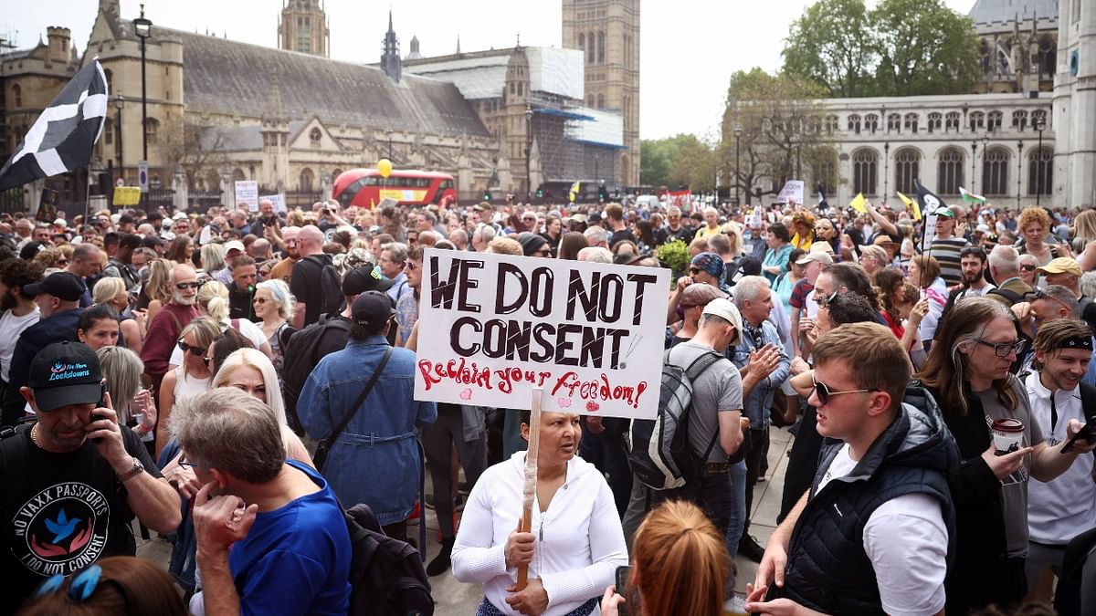 A woman holds a sign as demonstrators participate in an anti-lockdown and anti-vaccine protest, amid the spread of the coronavirus disease (Covid-19), at Parliament Square in London.