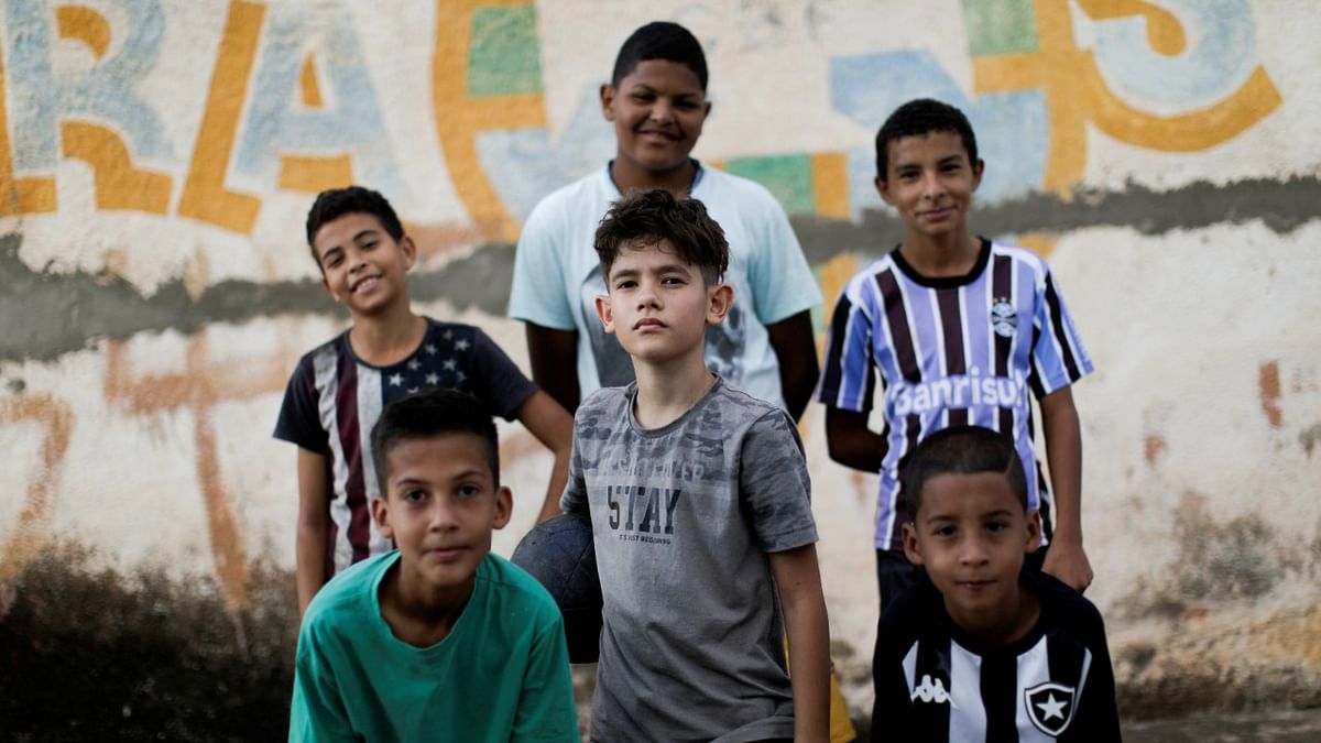 Children pose for a photo after playing soccer in a street at the neighborhood of Ceilandia in Brasilia. Credit: Reuters Photo