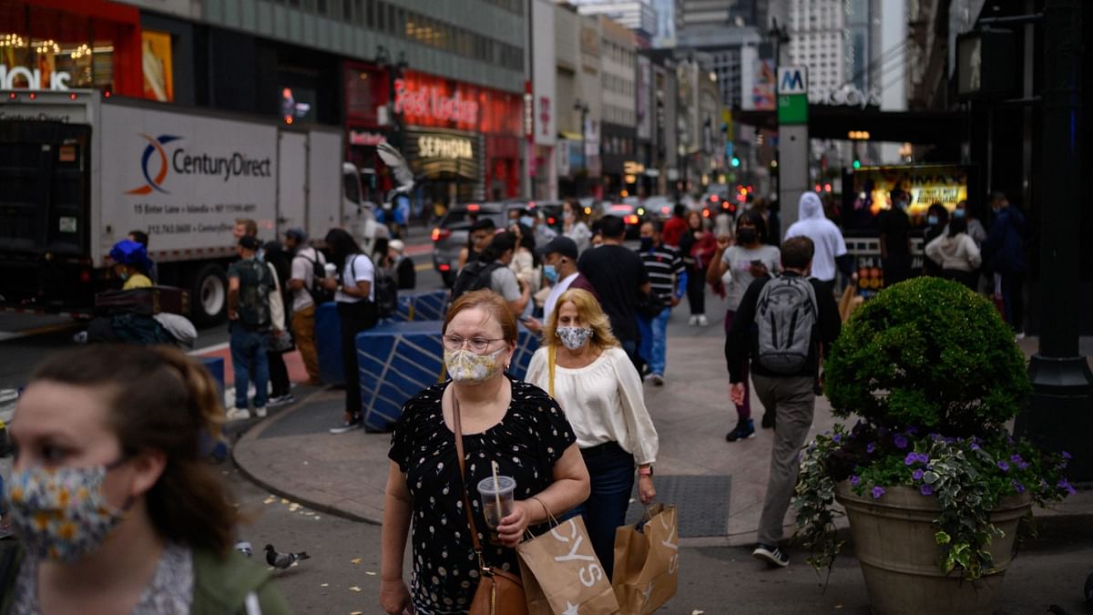 Pedestrians wearing face masks pass along a street in Manhattan, New York. Credit: AFP Photo