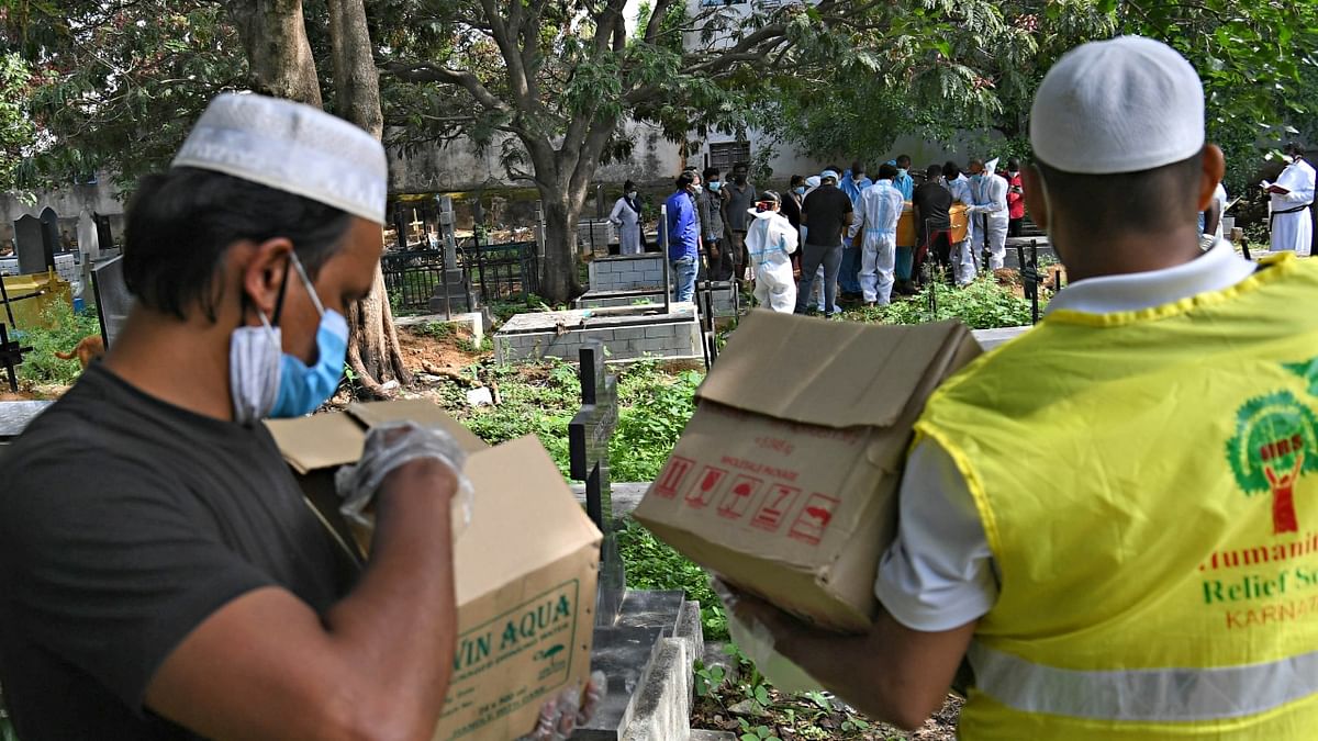 At 1.30 pm, on a partially overcast day in Bengaluru, a group of youngsters, half-clad in PPE kits, are taking a break as they sit on old tombs to have lunch in the shade of trees at the CSI cemetery in Adugodi.